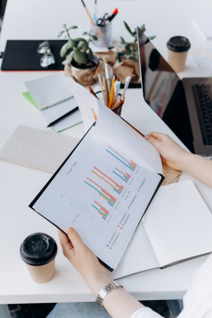 Hands reviewing graphs and charts in a modern office setting, analyzing data trends.